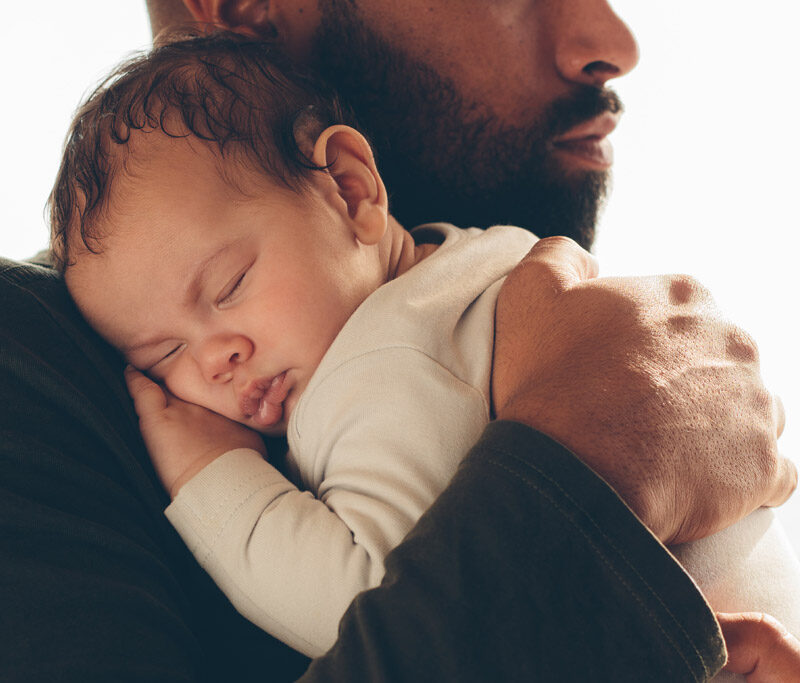 Sleeping newborn on the male shoulder