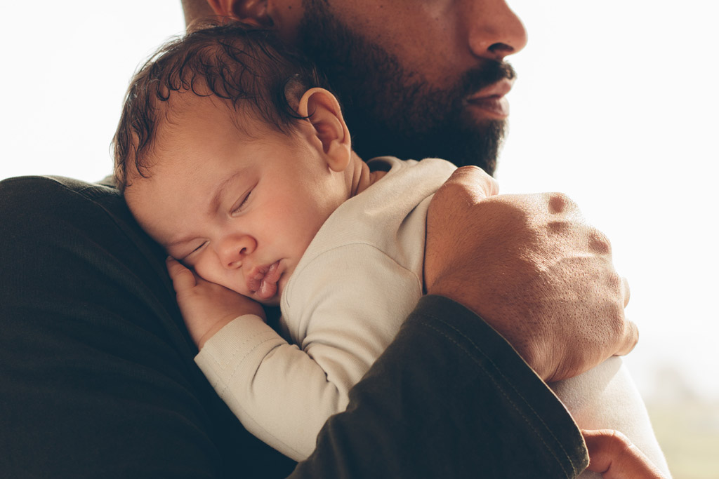 Sleeping newborn on the male shoulder